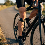 Cycliste sur route portant la sangle de genou noire sous la rotule